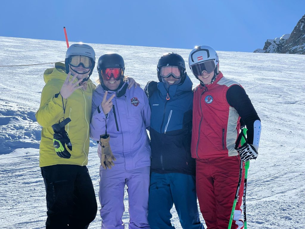 Skilehrer in blauer Jacke unterrichtet Gruppe auf verschneiter Piste in Kaprun