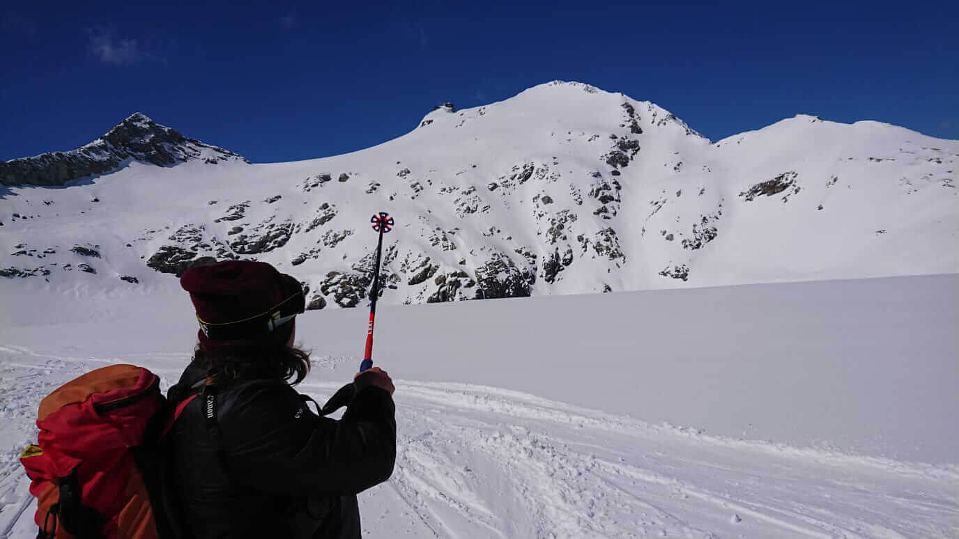 Person im Schnee mit Skistock, hochalpine Landschaft und klare blaue Himmel in Kaprun.
