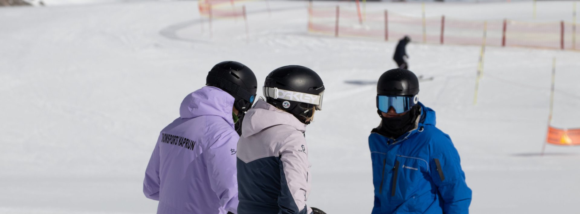 Skilehrer führt kleine Gruppe beim privaten Skiunterricht im verschneiten Skigebiet Kaprun